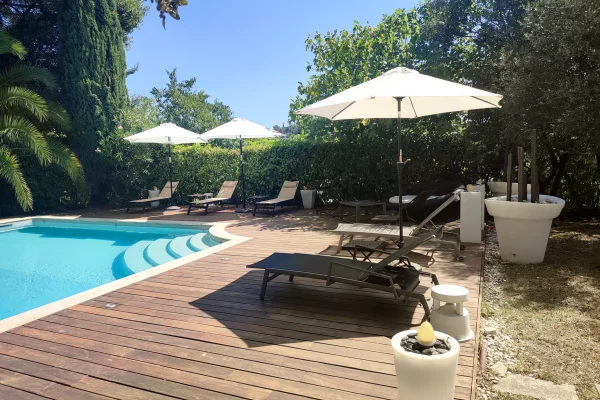 Des chaises longues installées au bord de la piscine de la Bastide Castella, chambres d'hôte de charme à Montpellier